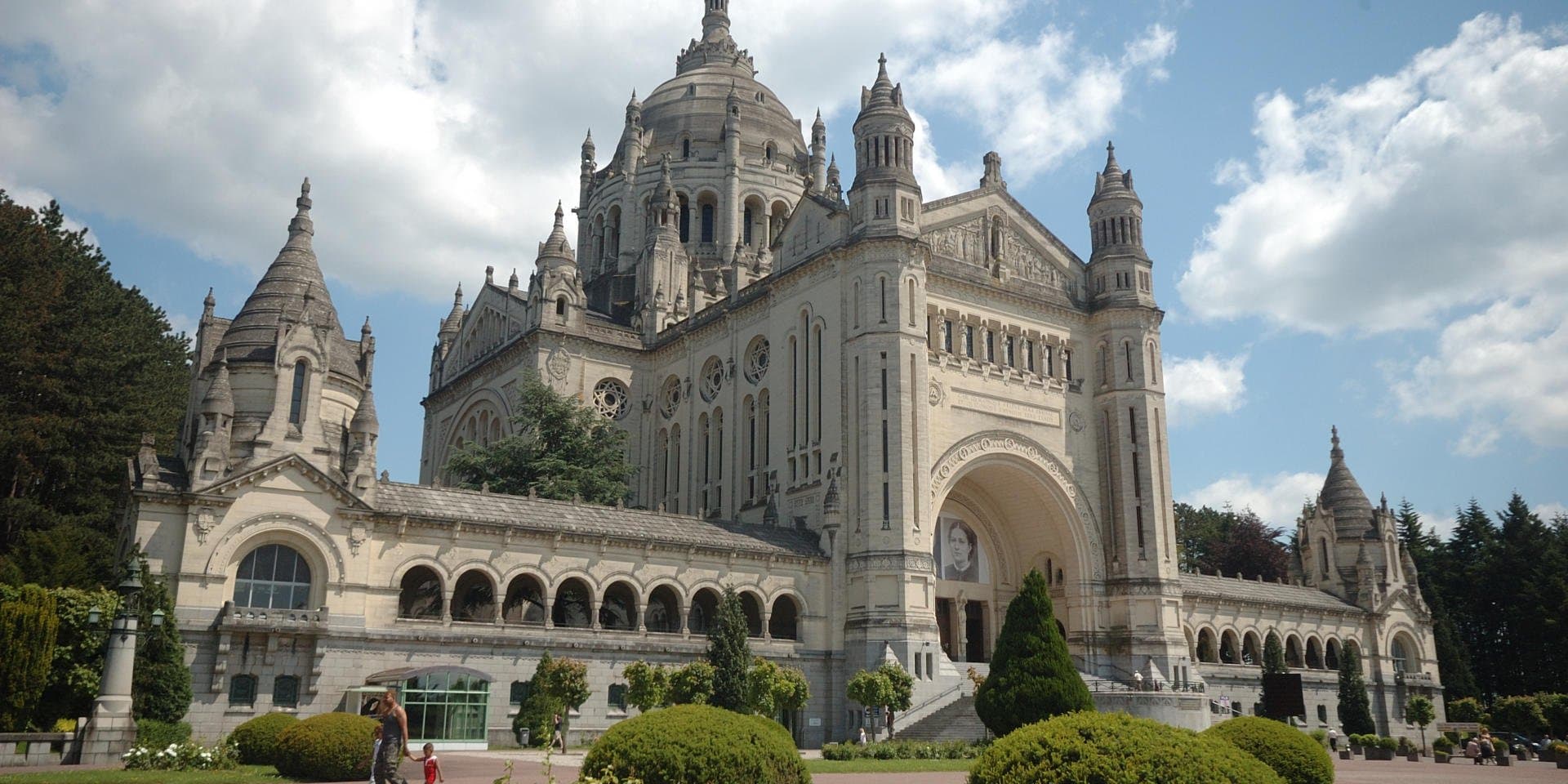 Petit train touristique garé devant la Basilique Sainte-Thérèse de Lisieux en Normandie
